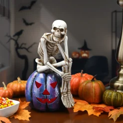 11 in. Halloween Skeleton Resting on a Purple Galaxy Jack O Lantern Indoor Decorations